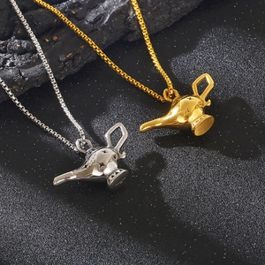 Detailed view of Aladdin lamp pendants in gold and silver finish on textured stone