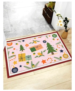 Pink Christmas doormat with festive trees and gifts on wooden floor in home entryway