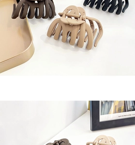 Detailed view of matte large pumpkin hair claws in dark brown, beige, and black colors