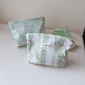 Detailed view of small floral cotton makeup bags with simple wish label and zipper
