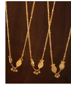 Detailed macro of golden fish pendants with bead charms on delicate titanium steel chains