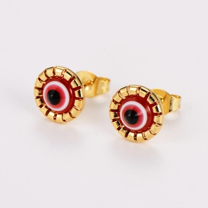Close-up of golden stainless steel stud earrings featuring a red evil eye pattern detail