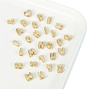 18K gold plated brass bubble letter beads for DIY necklaces and bracelets on white tray