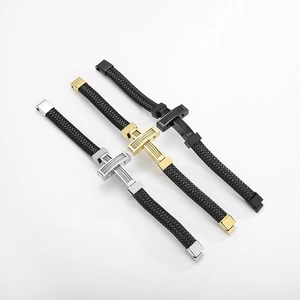 Detailed view of woven leather bracelets with metallic cross accents in silver gold and black