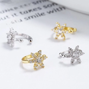 Macro shot of silver and gold starburst ear cuffs with sparkling zircon crystals