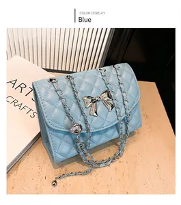 Vue détaillée du sac bandoulière bleu matelassé avec nœud argenté et chaîne