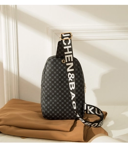 Close-up of printed crossbody chest bag with decorative woven strap and gold buckle