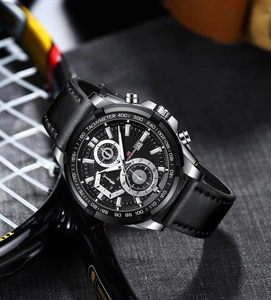 Close-up of black sport watch dial with chronograph features and leather strap details