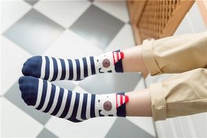 Close-up of navy striped kids cotton socks featuring cute white bear with holiday hat