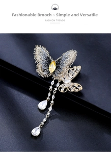Détail macro de la broche papillon avec chaînes en zircon et gemme jaune incrustée
