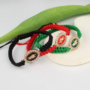 Macro shot of colorful woven bracelets with Saint Mary metal pendants and rhinestones
