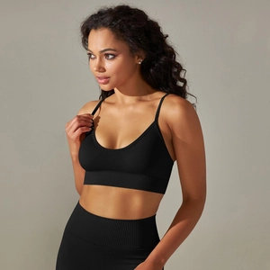 Detail of black seamless ribbed yoga bra showing thin straps and V-neckline texture