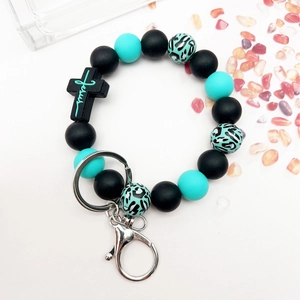 Silicone bead keychain with cross pendant and Jesus engraving on white background