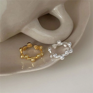 925 sterling silver beaded rings in gold and silver finish on a ceramic plate