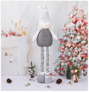 Detail of retractable Swedish gnome doll with silver accents by a festive fireplace
