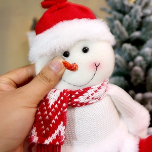 Makroaufnahme von Plüsch-Schneemann-Puppe mit roter Strickmütze und Schal-Texturdetails