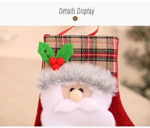 Detail showing plush Santa Claus head with brown plaid hat and holly on Christmas stocking