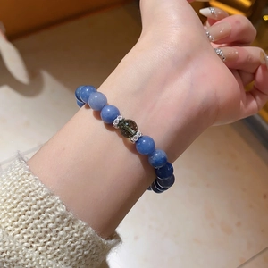 Detail view of a blue zircon crystal beaded stretch bracelet on a wrist