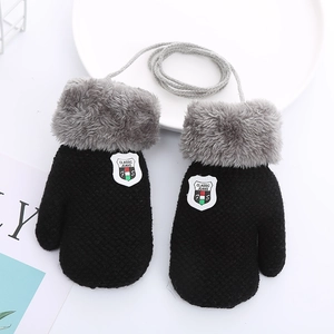 Detail view of black knit children gloves with gray plush lining and hanging string