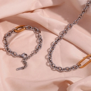 Detail of 18K gold and silver chunky chain set with an engraved metal brand tag