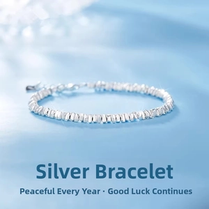 Macro shot of silver crushed nugget bead bracelet on a light blue gradient background