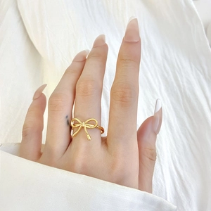 Bague nœud dorée élégante pour femme avec design évidé minimaliste portée à la main