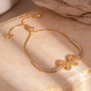 Dettaglio del bracciale a farfalla dorato con zirconi baguette e chiusura a scorrimento