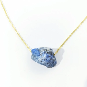Minimalist golden necklace featuring a large irregular natural blue raw stone pendant