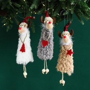 Three plush Christmas reindeer ornaments in white, grey, and brown hanging on a festive tree