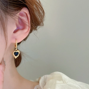 Vintage gold heart drop earrings with navy blue enamel on model side view