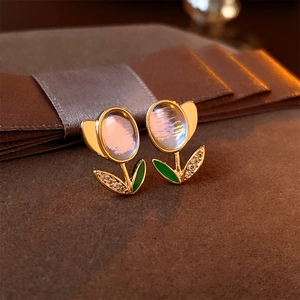 Macro shot of tulip flower earrings with moonstone gems and green enamel detail