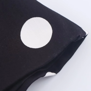 Close-up of black fabric with white polka dots showing textile texture and stitching