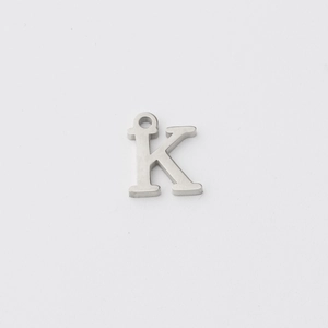 Close-up of polished stainless steel K letter pendant with a smooth mirror finish