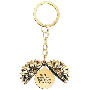 Detail of opening sunflower keychain with She believed she could so she DID engraving