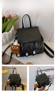 Detail of black PU leather backpack with FASHION metal plate and plush charm accessory