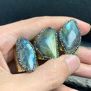 Detail view of gold labradorite rings with blue flash and black crystal pavé accents