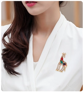 Detailed view of a giraffe brooch with colorful crystals on a white fabric background