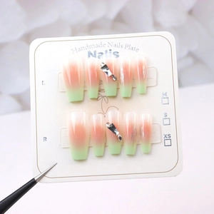 Detail of green tea gradient handmade press-on nails with geometric rhinestones decoration