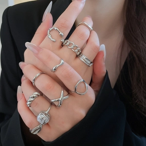 Close-up of silver starfish ring set with pearl detail on a model's hand with suit