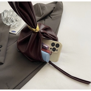 Detail view of the soft pleated leather interior with gold ring accent and storage space