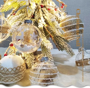 Detail of Christmas balls with elk patterns and pearls on a festive lit pine branch