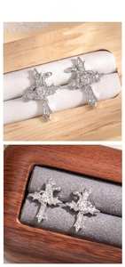 Close-up of gothic cross earrings with white zircon pave setting in jewelry box