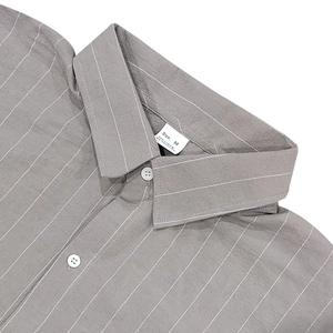Detail of the collar and linen fabric label on a grey vertical striped men's shirt