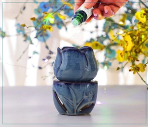 Macro detail of blue tulip ceramic essential oil burner with floral cutout base