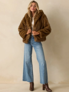 Brown faux fur hooded jacket styled with light blue wide-leg jeans and dark boots