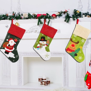 Detailed view of three linen Christmas stockings hanging on a decorated white fireplace