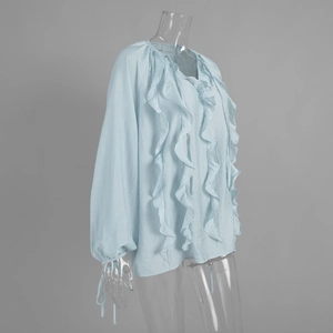 Detail of light blue lantern sleeves and ruffled cuffs on a French V-neck blouse