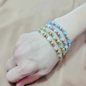 Detail of colorful cat eye bead bracelets with engraved gold and silver accents
