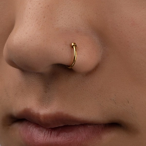 Macro shot of gold-plated non-piercing C-shaped nose ring on model for street style look