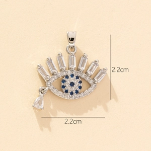 Macro shot of silver evil eye pendant with blue zircons measuring 2.2cm by 2.2cm